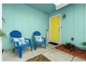 Inviting front porch with seating and a vibrant yellow door creating a welcoming entrance at 3 Castle Manor Dr, Ormond Beach, FL 32174