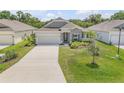 Inviting exterior view of a single-story home featuring well-manicured lawn and complemented by mature trees at 1012 Bradford Ridge Dr, Leesburg, FL 34748