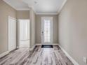 Elegant entryway featuring wood-look tile flooring, decorative front door, and neutral wall paint at 1012 Bradford Ridge Dr, Leesburg, FL 34748