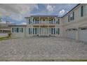 Elegant home with a stone driveway, a second-story balcony, and striking blue shutters that add a pop of color at 1221 Commodore Dr, New Smyrna Beach, FL 32168
