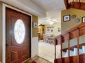 Inviting entryway with decorative glass door, tiled floor, and a staircase leading to the upper level at 133 Cedar Dunes Dr, New Smyrna Beach, FL 32169