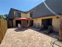 A charming paver patio offers ample seating and an umbrella, perfect for outdoor relaxation and entertaining at 133 Cedar Dunes Dr, New Smyrna Beach, FL 32169