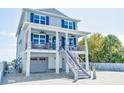 Two-story home with blue shutters and charming front porch features seating and a brick driveway at 1373 N Atlantic Ave, New Smyrna Beach, FL 32169