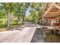 View of the property's driveway, highlighting mature trees, landscaping, and additional building at 1663 Hideaway Ln, Edgewater, FL 32132