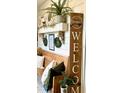 Inviting entryway with rustic wooden bench, decorative pillows and 'Welcome' sign at 181 Caryota Ct, New Smyrna Beach, FL 32168