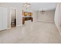 Spacious, open-concept living room with tile flooring, chandelier lighting and seamless flow to the kitchen at 1868 Pine Tree Dr, Edgewater, FL 32141