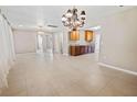 Open-concept living room boasts natural light, tile flooring and an elegant chandelier lighting at 1868 Pine Tree Dr, Edgewater, FL 32141