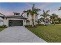 Beautiful exterior elevation with a large garage, front lawn, and palm trees at 212 Due East St, New Smyrna Beach, FL 32169