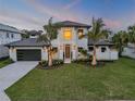 Beautiful exterior elevation with a large garage, front lawn, and palm trees at 212 Due East St, New Smyrna Beach, FL 32169