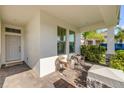 Charming front porch featuring cozy chairs and a welcoming entrance at 220 Venetian Palms Blvd, New Smyrna Beach, FL 32168