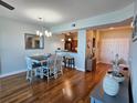 Open dining area with wood floors and a view into the kitchen area with stainless steel appliances at 2801 S Ridgewood Ave # 512, South Daytona, FL 32119