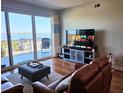 Bright living room with hardwood floors, leather furniture and balcony access offering water views at 2801 S Ridgewood Ave # 512, South Daytona, FL 32119