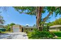 Charming single-story home with mature trees, stone accents, and an attached single car garage at 2914 Sabal Palm Dr, Edgewater, FL 32141