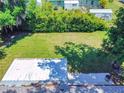 Aerial shot of a large, flat backyard with mature trees providing shade, partially covered patio at 3013 Lime Tree Dr, Edgewater, FL 32141