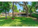 Green backyard featuring mature trees, offering a tranquil retreat at 3016 Mango Tree Dr, Edgewater, FL 32141