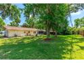 Lush backyard with mature trees and a covered lanai, perfect for outdoor relaxation at 3016 Mango Tree Dr, Edgewater, FL 32141