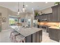 Well-appointed kitchen featuring granite countertops, stainless steel appliances, and decorative pendant lighting at 3219 Modena Way, New Smyrna Beach, FL 32168