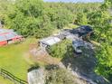 Aerial view of a home with multiple outbuildings and a vast tree coverage at 416 Western Rd, New Smyrna Beach, FL 32168