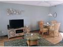 Cozy living room featuring a decorative turtle wall sculpture, a TV, and rattan furnishings at 4501 S Atlantic Ave # 5060, New Smyrna Beach, FL 32169