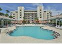Relaxing pool area with shaded cabanas, lounge chairs, and beautiful landscaping, perfect for outdoor enjoyment at 5300 S Atlantic Ave # 20-507, New Smyrna Beach, FL 32169