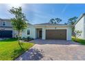 Charming home with beautiful landscaping, a two-car garage, and a brick paver driveway at 5607 Estero Loop, Port Orange, FL 32128