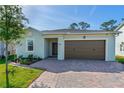Inviting home with a two-car garage and a well-maintained front yard with flower beds at 5607 Estero Loop, Port Orange, FL 32128