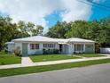 Traditional white brick home with a lush green lawn under a blue sky with fluffy clouds at 600 Magnolia St, New Smyrna Beach, FL 32168
