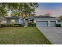 Charming single-story home featuring a three-car garage, manicured lawn, and a welcoming front entrance at 634 Woodford Dr, Debary, FL 32713