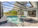 Screened pool and spa offer a refreshing escape, complemented by brick pavers and tranquil water views at 634 Woodford Dr, Debary, FL 32713