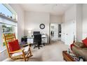 Bright home office features a large window, neutral carpet, and an organized workspace with a desk and chair at 6436 Longlake Dr, Port Orange, FL 32128