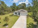 Beautiful single-story home featuring an attached garage, driveway, green lawn, and mature landscaping at 703 Volco Rd, Edgewater, FL 32141