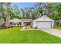 Charming single-story home with attached garage and manicured front yard at 795 Sugar Cane Ln, Port Orange, FL 32129