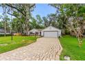 Single-story home featuring a brick driveway, attached garage and well-maintained lawn at 795 Sugar Cane Ln, Port Orange, FL 32129