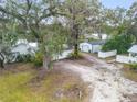 Exterior view of the property featuring the garage, gravel drive and mature tree with Spanish moss at 801 Canal St, New Smyrna Beach, FL 32168