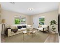 Bright living room with hardwood floors, large windows, neutral walls, a cream colored sofa, and stylish modern décor at 1364 W Hartley Cir, Deltona, FL 32725