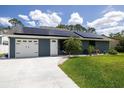 Beautiful home showcasing solar panels, a lush green lawn, and an attached two-car garage at 2797 Nordman Ave, New Smyrna Beach, FL 32168