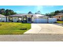 Charming single-story home featuring a well-manicured lawn, solar panels, and an attached two-car garage at 2820 Tamarind Dr, Edgewater, FL 32141