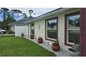 Beautifully landscaped side yard with decorative flowerpots and modern window trim at 2820 Tamarind Dr, Edgewater, FL 32141