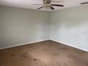 A neutral bedroom features a ceiling fan and dated carpet at 3048 Unity Tree Dr, Edgewater, FL 32141