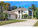 Spacious home with a three-car garage, a grand entrance with columns, and mature landscaping for added curb appeal at 305 Country Circle E Dr, Port Orange, FL 32128
