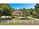 Charming two-story home with landscaped yard, white fence and mature trees offers curb appeal at 305 Country Circle E Dr, Port Orange, FL 32128