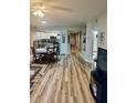 Open living area featuring wood-look floors, dining space and a partial view of the kitchen at 5300 S Atlantic Ave # 3-405, New Smyrna Beach, FL 32169