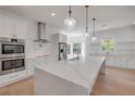 Bright kitchen with white cabinets, marble island, and pendant lighting at 1371 Melonie Trl, New Smyrna Beach, FL 32168