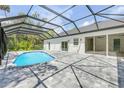 Backyard view of the sparkling pool, patio, and screened enclosure of this pristine Florida home at 1371 Melonie Trl, New Smyrna Beach, FL 32168