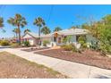 Well-maintained home with a tidy front yard, a quaint front porch, and mature palm trees at 208 Crawford Rd, New Smyrna Beach, FL 32169