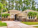 Inviting single-Gathering home with a beige exterior, tile roof, attached garage, and lush green lawn at 3455 Pegaso Ave, New Smyrna Beach, FL 32168