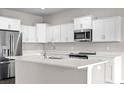 Modern kitchen featuring white cabinets, stainless steel appliances, and a spacious center island at 377 Palm Dr, New Smyrna Beach, FL 32168