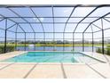 Screened-in pool offers a tranquil view of the lake with a fountain at 6277 W Fallsgrove Ln, Port Orange, FL 32128
