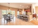 Bright kitchen and dining area with stainless steel appliances, granite countertops, and a cozy breakfast bar at 6950 Vintage Ln, Port Orange, FL 32128