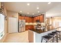 Well-lit kitchen with stainless steel appliances, granite countertops, and a convenient breakfast bar at 6950 Vintage Ln, Port Orange, FL 32128